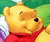 Static pixelated image of a yellow cartoon bear wearing red clothing against green background with partial white and purple elements.