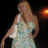 A pixelated figure in a light-colored dress stands against a dark background with an orange glow on the right.