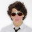 Six distinct pixelated images of a person with brown curly hair in various poses and expressions, including sunglasses, crossed arms, and text overlay.
