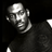 Static grayscale pixel art of a person's face and upper torso against black background, with high-contrast lighting emphasizing facial features and clothing texture.