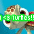 Pixelated turtle head with wide eyes and open mouth against blue background, green banner reading 'Turtles!' visible on left side of frame.