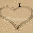 Pixelated heart-shaped sand drawing with text "I Love Zackk" in black block letters on a beige background.