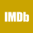 White pixelated text "IMDb" on solid mustard-yellow background with slight transparency effects on letter edges.