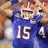 Pixelated image of a football player in blue uniform with number 15, orange helmet, and white helmet stripe, next to blue background with orange text.