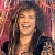 Two side-by-side figures with long curly hair; left figure smiles broadly, right figure has neutral expression.