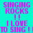A cyan background displays pink pixelated text reading "SINGING ROCKS !! I LOVE TO SING !" in a pattern with white rectangular overlays
