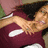 A pixelated image shows a person with dark hair lying on their back, wearing a maroon top with white accents.