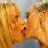 A 48x48 pixel animated buddy icon featuring two blonde women kissing on the left side and green text reading "Original Icons .com" on a dark green background on the right side, displayed as a contact sheet with two frames.