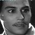 Black-and-white pixelated close-up of a person's face with visible eyes, nose, mouth, and partial clothing details.