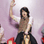A person with long dark hair in a white shirt and brown vest rides a mechanical horse against a light purple background, raising one arm while text overlays change.