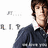Pixelated image of a person with brown hair wearing a dark blue jacket over a white shirt, with partial text fragments on the left side.