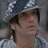 Pixelated image of a person wearing a patterned cap and light-colored shirt, with overlaid pixelated text in four sections.