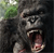 Pixelated close-up of a chimpanzee's face with mouth open, showing teeth and tongue, against dark background with green foliage on left.