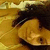 A person with dark hair and light skin lies on a patterned surface, eyes open in close-up view.