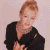 A pixelated image of a person with short light brown hair wearing a black top, positioned next to green text on a dark background.