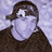 Pixelated image of a person with brown hair and dark clothing against light background, next to blue pixelated text on black background.