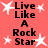 A static image with a coral background displays four identical text blocks reading "Live Like A Rock Star" in black pixelated font, surrounded by white star shapes.