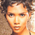 Pixelated close-up of a person with curly brown hair, light skin, and neutral expression against a textured background.