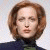 A pixelated image of a person with short brown hair and closed eyes, wearing dark clothing against a light background.