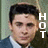Pixelated portrait of a person with dark hair wearing a blue jacket over a white shirt, with vertical white text 'HOT' on the right side.