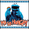 Blue furry character with large eyes holds a cookie, mouth open, text 'ME SO HUNGRY' in orange below, blue checkered border.