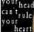 Pixelated grayscale text on black background reads 'your head can't rule your heart' in three lines with uneven spacing.