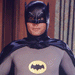 Batman character in gray suit with black cape and yellow bat symbol, displayed across nine color-filtered showing red, orange, green, blue, purple variations