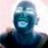 Pixelated static image of a figure with blue-toned skin, dark hair, and visible teeth against a light background.