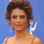Static pixelated image of a woman with brown curly hair wearing a light-colored strapless top against a blue background, featuring visible dithering and anti-aliasing artifacts.