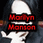 A pixelated image of a person with long dark hair and white face paint, wearing red lipstick, in three showing text overlays
