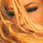 Pixelated close-up of a person's face with warm orange and brown tones, showing eyes, nose, and mouth in low-resolution detail.