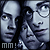 Pixelated static image of three stylized faces with monochrome blue-gray tones and visible text 'mm!' at bottom left.