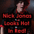 Pixelated image of a person with light skin and dark hair in red clothing, overlaid with bold red text reading 'Nick Jonas Looks Hot In Red!' on black background.