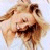 Pixelated static image of a person with light brown hair, closed eyes, and a neutral expression against a light blue background.