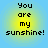 Four identical pixelated text arranged in a on a blue background, each displaying "You are my sunshine!" with yellow-to-blue gradient circles behind the text