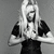 Black-and-white pixelated image of a person with long hair wearing dark clothing, holding hands near the chest in one view and facing forward in another.