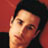Pixelated static image of a person's face with dark hair against a red background, rendered in low-resolution 48x48 pixels with visible dithering and color blending.