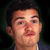 Static pixelated portrait of a person with short dark hair against a dark background, rendered in low-resolution 256x256 pixels.