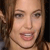 A pixelated close-up of a person with light brown hair, showing the face from the forehead to the chin with a slight smile.