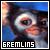 Pixelated close-up of a gremlin-like creature's face with large eyes and pinkish skin, set against blue background with text 'GREMLINS' at bottom.