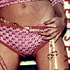 A person's torso and legs in a low-angle close-up, wearing pink patterned underwear with red trim and a heart drawn on the abdomen.