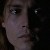 Pixelated close-up of a person's face with dark background, showing eyes, nose, and mouth in low-resolution detail.