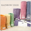 Colorful rolled fabric rolls in orange, yellow, green, purple, pink, and blue arranged on a light surface with 'RAINBOW DOGS' text above.