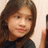 Pixelated close-up of a person with long brown hair wearing a dark top against a light background.