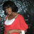 Pixelated image of a person with dark curly hair wearing red and white clothing against a pixelated background.