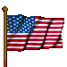American flag on brown pole with red and white stripes and blue field of white stars, waving in a of