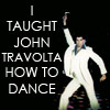 A person in a white jumpsuit with a blue collar raises one arm against a black background, with bold white text reading "I TAUGHT JOHN TRAVOLTA HOW TO DANCE".