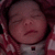 A child in a red and white checkered hooded garment with closed eyes, visible on three of an animated sequence