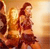 Pixelated image of two figures in warm tones with one figure holding a glowing object against a gradient background.