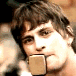 repeated images showing a person with dark hair holding a square brown object in their mouth, arranged in and